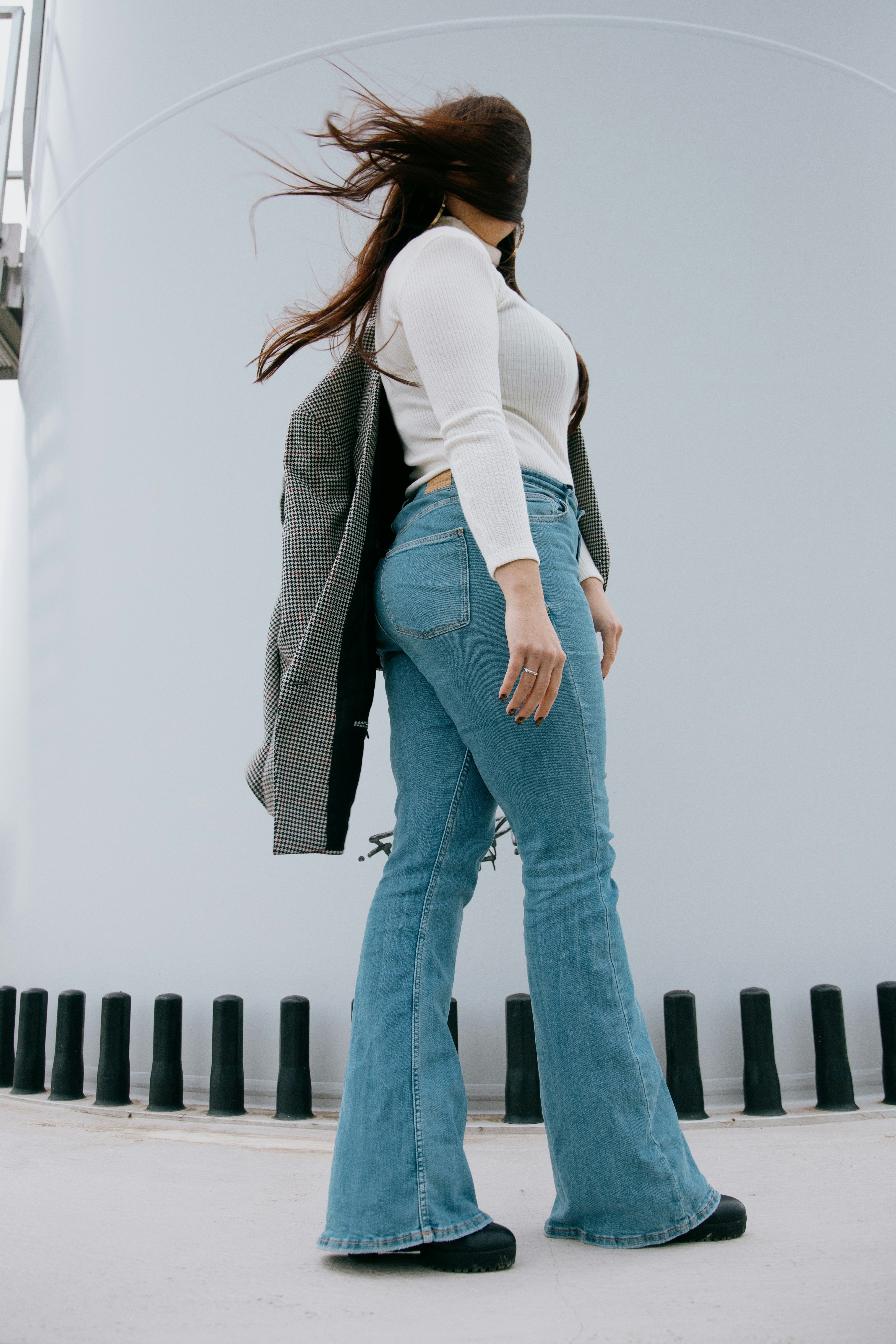 woman in white shirt and blue denim jeans standing